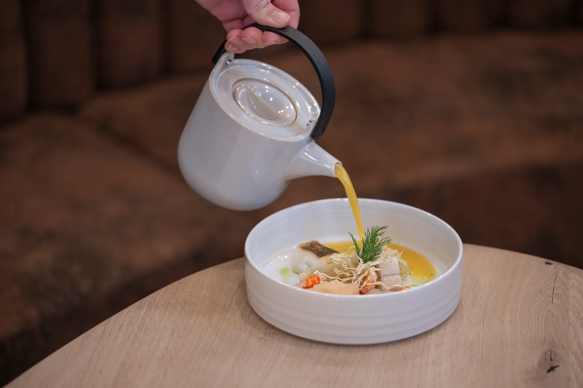 Gericht der Longevity Cuisine im Buff Medical Resort: Fisch und Flusskrebse, am Tisch mit Brühe aufgegossen (© Buff Medical Resort)